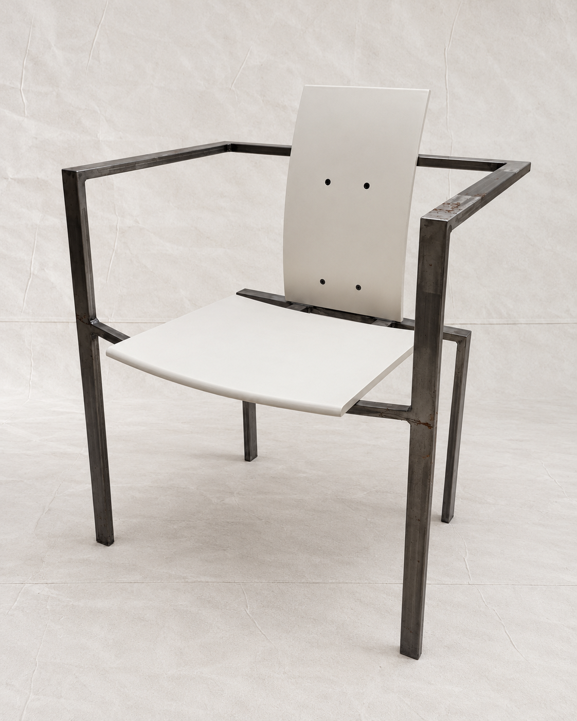 A modern armchair with a dark metal frame and white molded seat and back panels, photographed against a light gray tiled studio background.