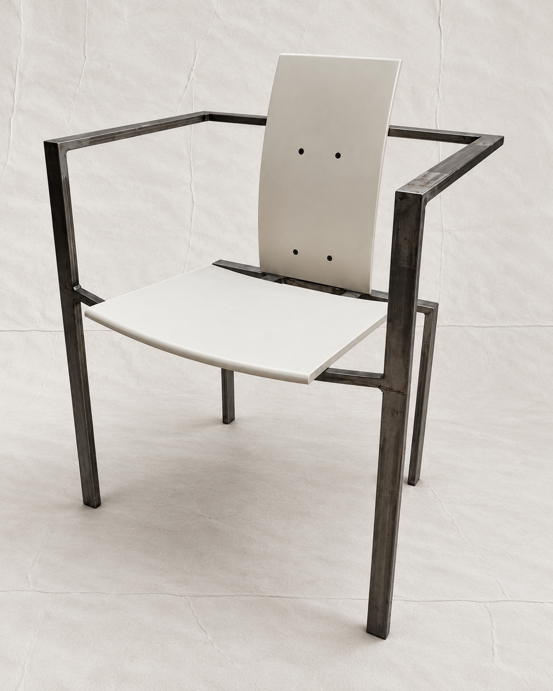 A modern armchair with a dark charcoal metal frame and white molded seat and back panels, photographed against a light gray fabric backdrop.