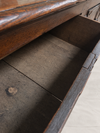 Close-up of an open dark wood drawer showing the interior wood grain and construction details.