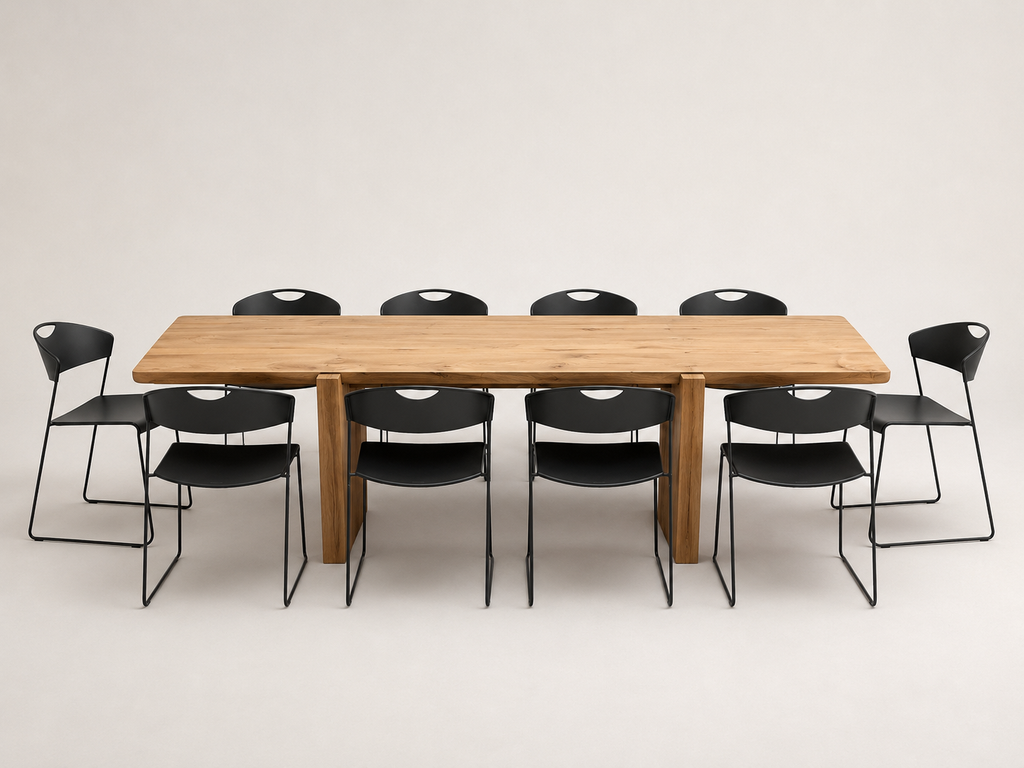 A rectangular wooden conference table with eight black metal-framed chairs, photographed against a seamless light gray studio background.