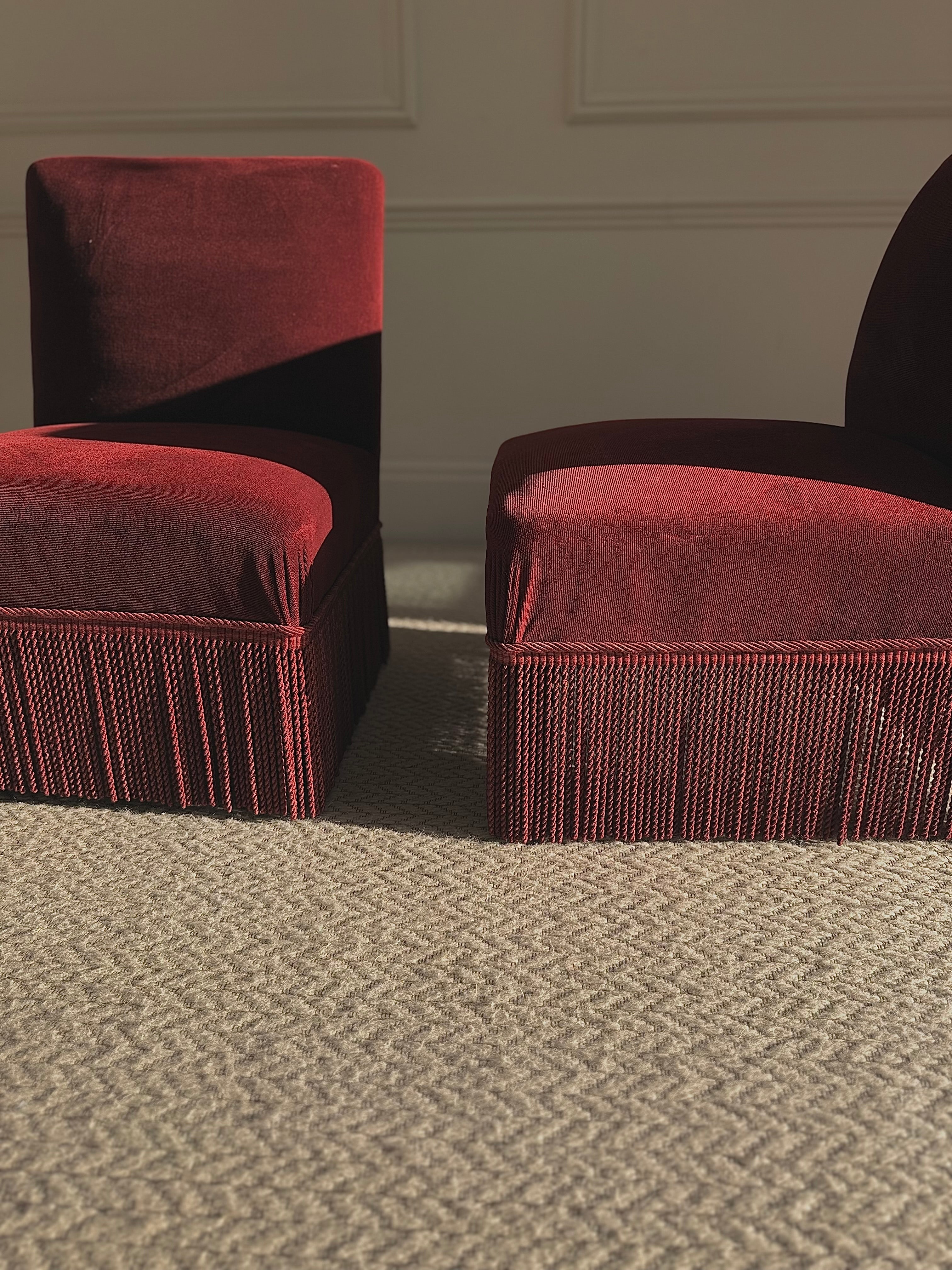 A pair of French Napoleon III red velvet slipper chairs with fringe