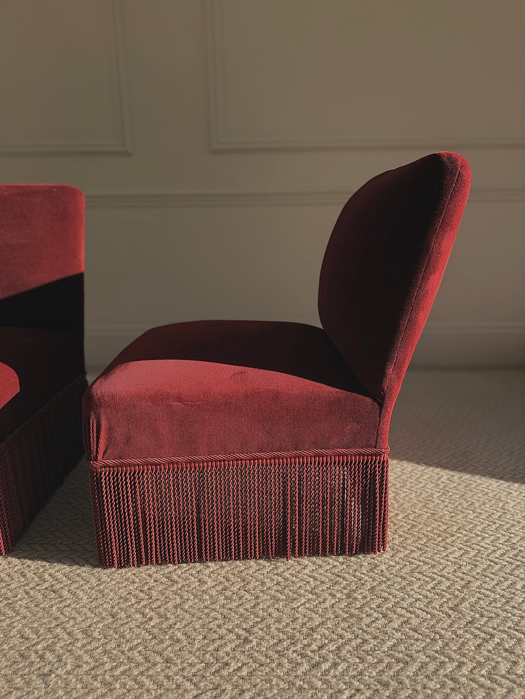 A pair of French Napoleon III red velvet slipper chairs with fringe