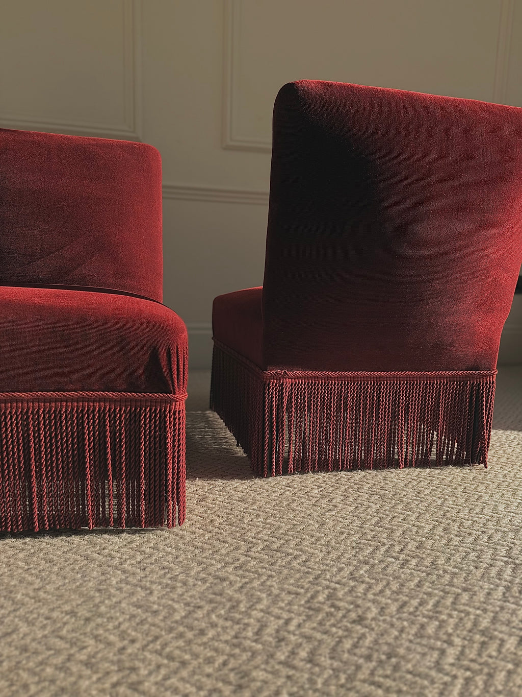 A pair of French Napoleon III red velvet slipper chairs with fringe