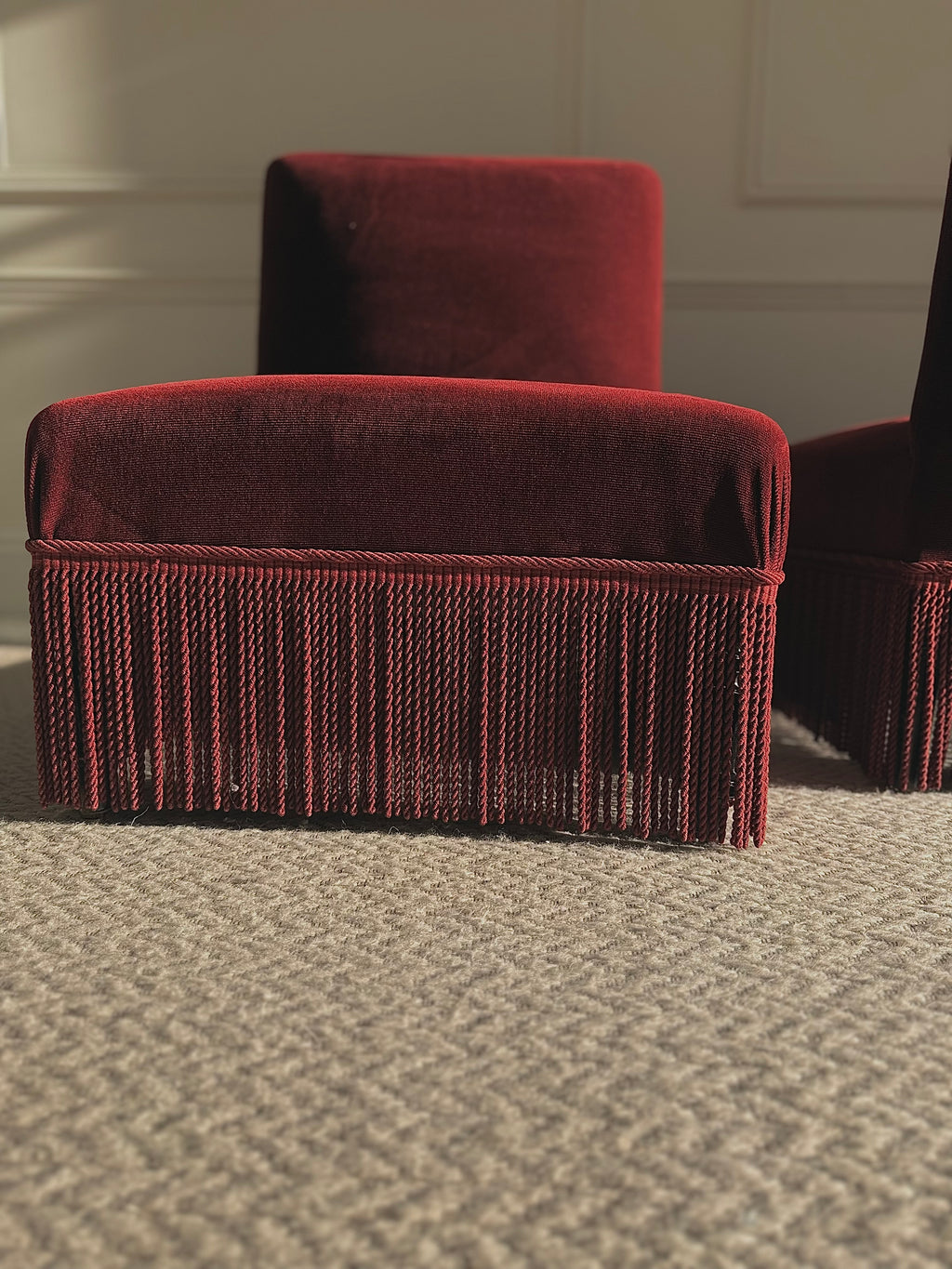 A pair of French Napoleon III red velvet slipper chairs with fringe