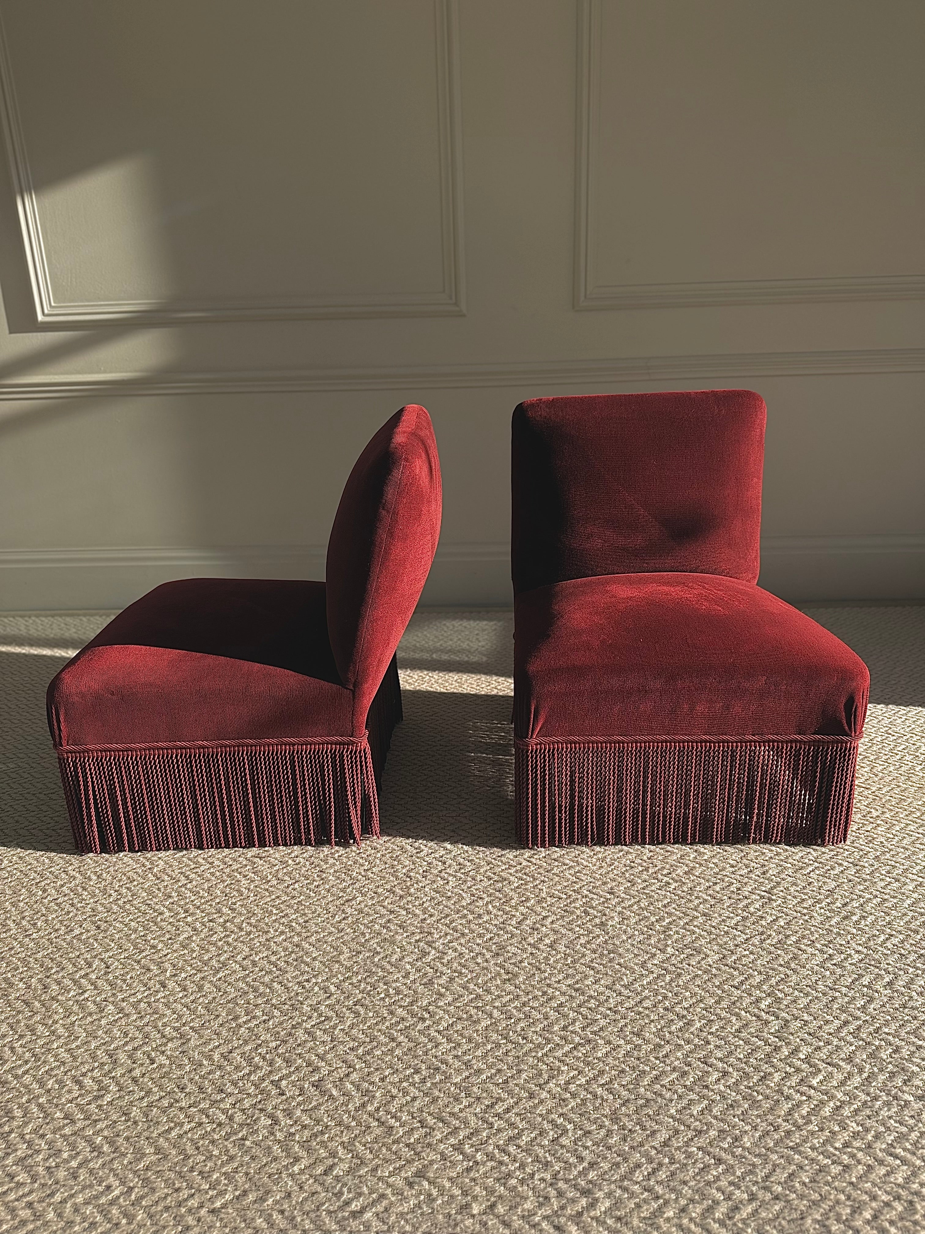 A pair of French Napoleon III red velvet slipper chairs with fringe