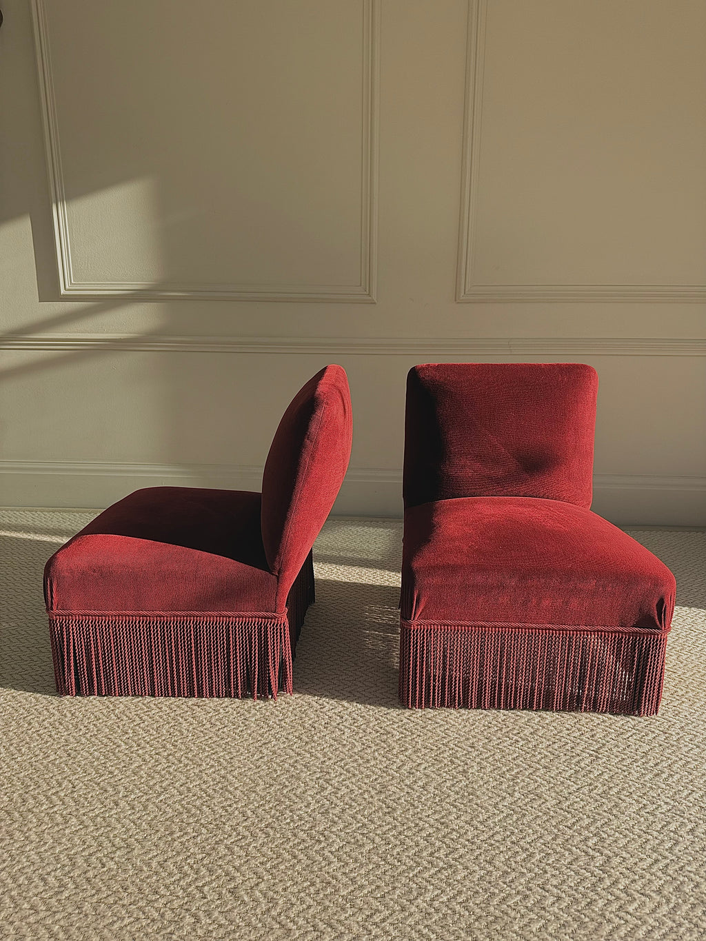 A pair of French Napoleon III red velvet slipper chairs with fringe