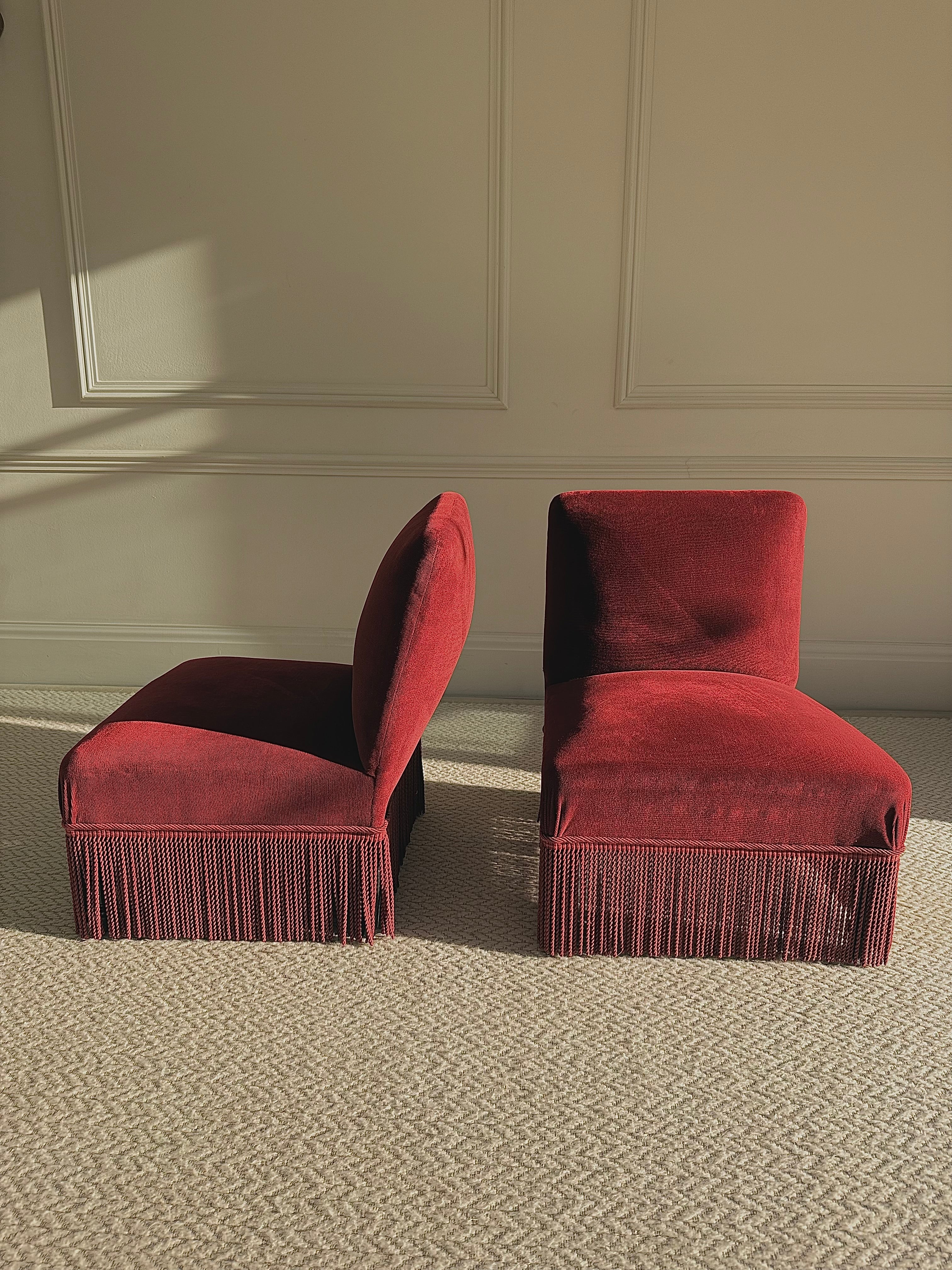 A pair of French Napoleon III red velvet slipper chairs with fringe