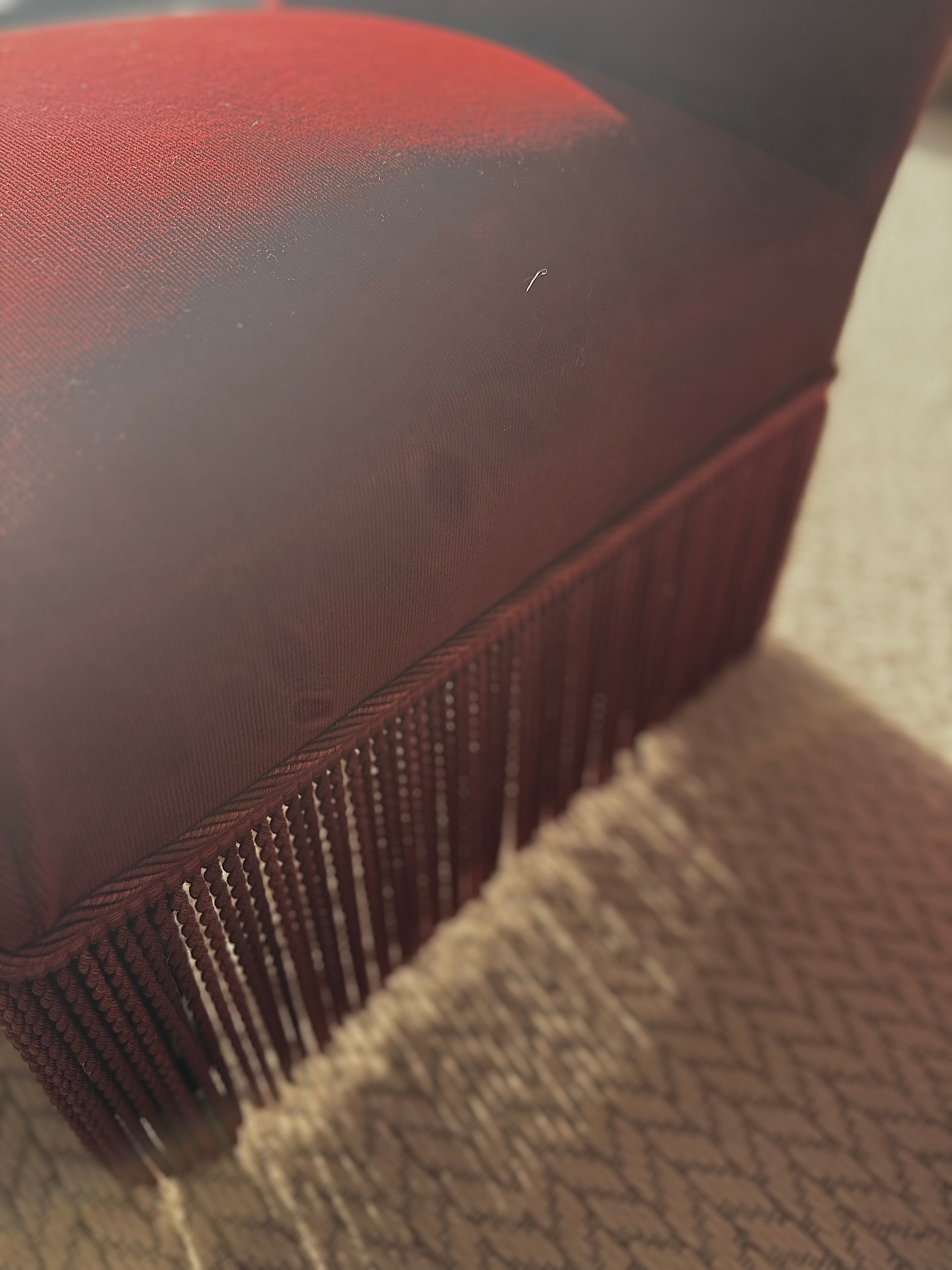 A pair of French Napoleon III red velvet slipper chairs with fringe