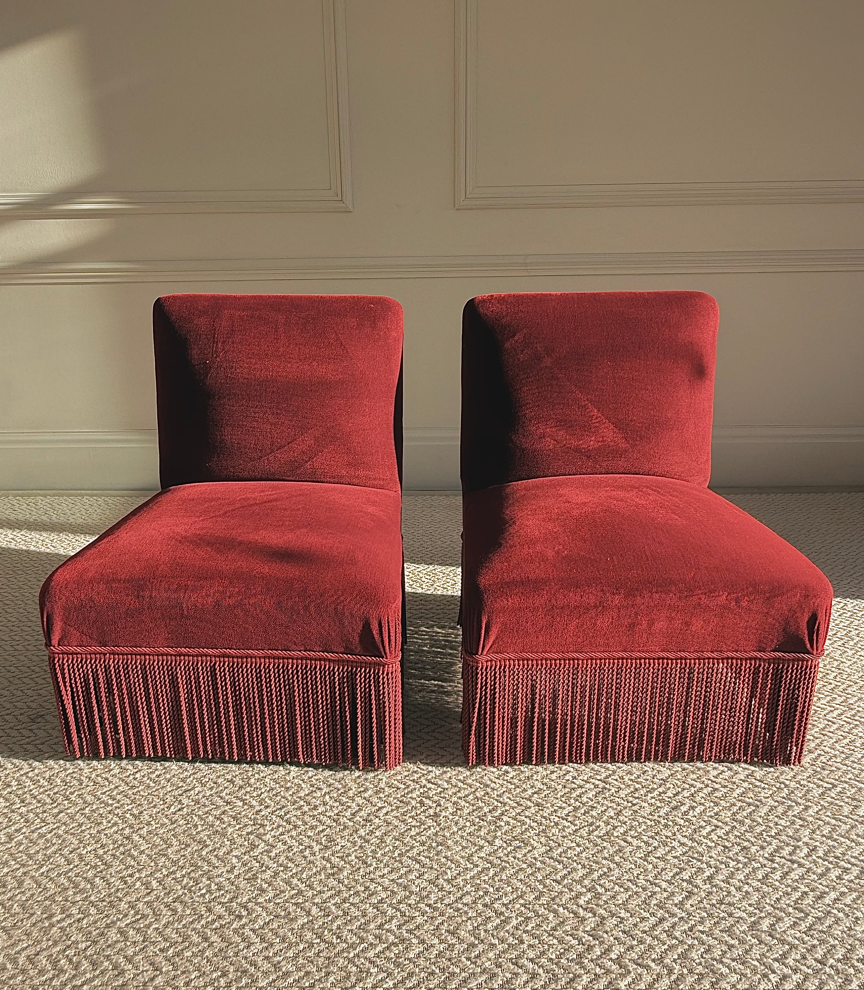 A pair of French Napoleon III red velvet slipper chairs with fringe