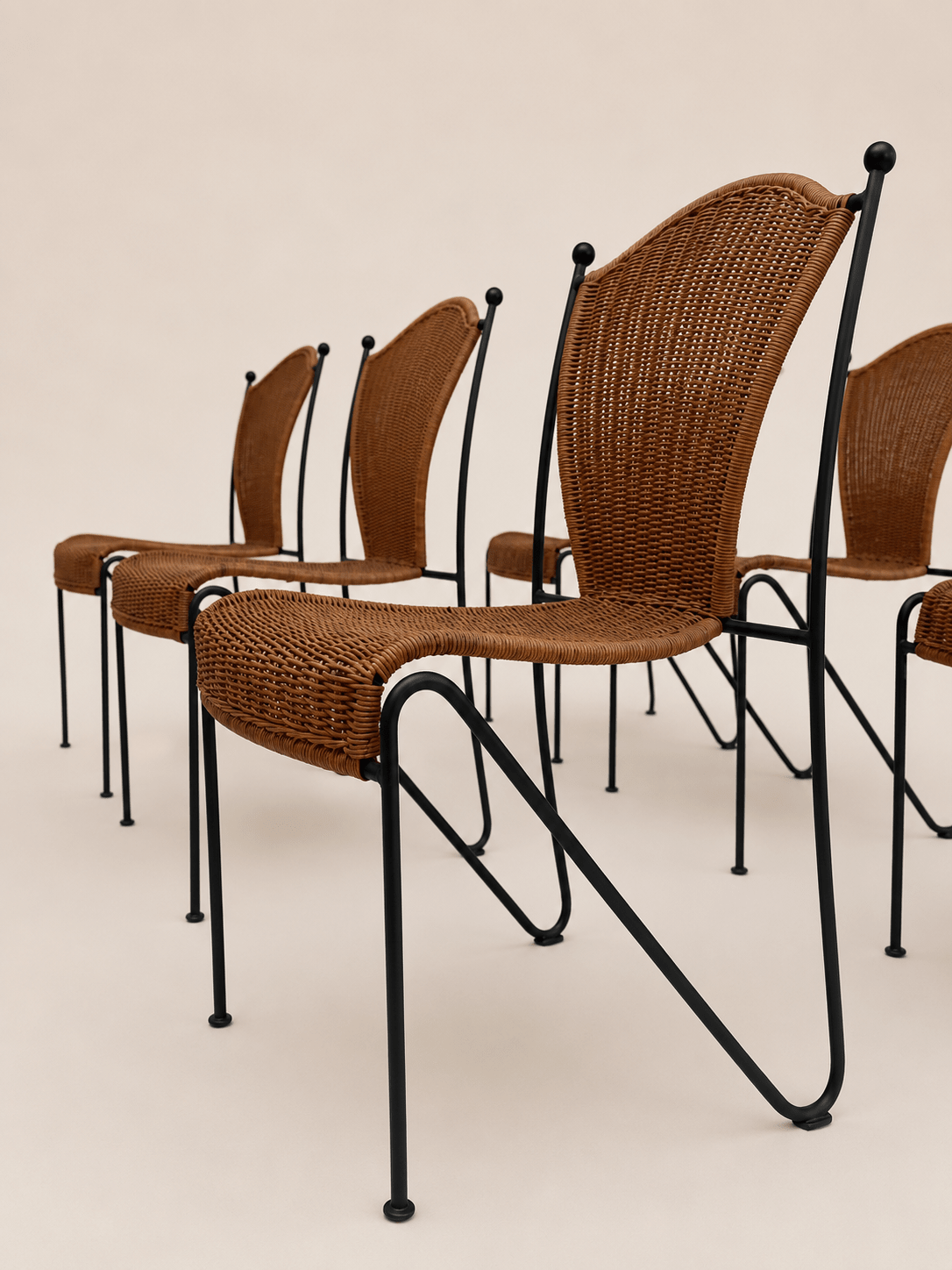 mid-century wicker and iron dining chairs - low side view across the grouped chairs