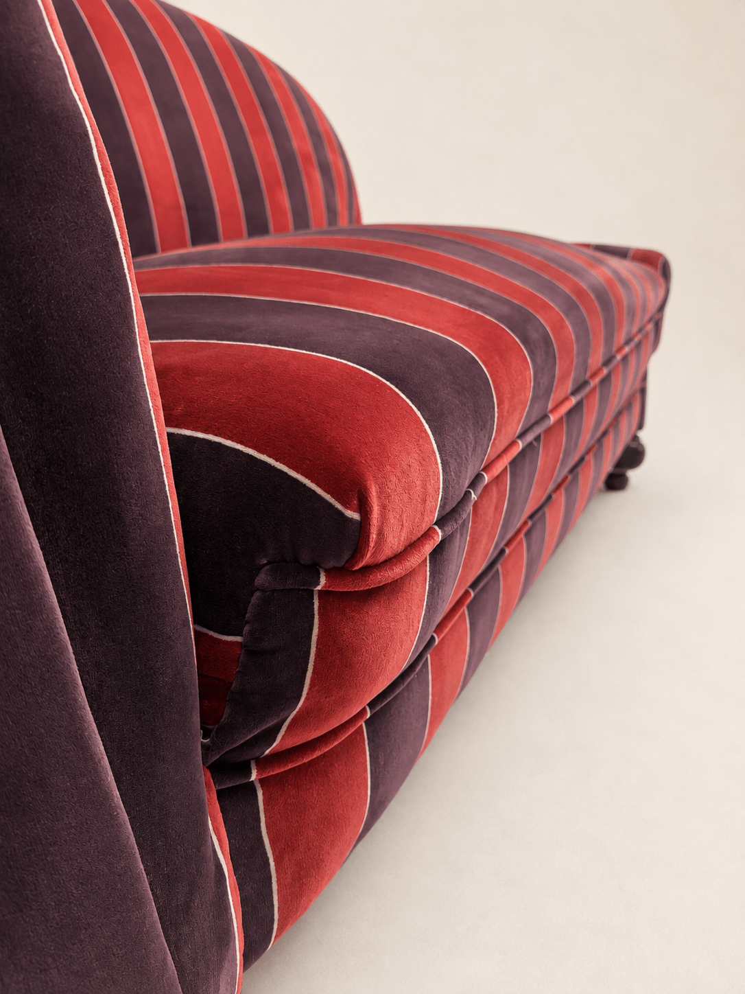 striped velvet curved-back two-seater sofa - left rolled arm and striped velvet upholstery, close-up