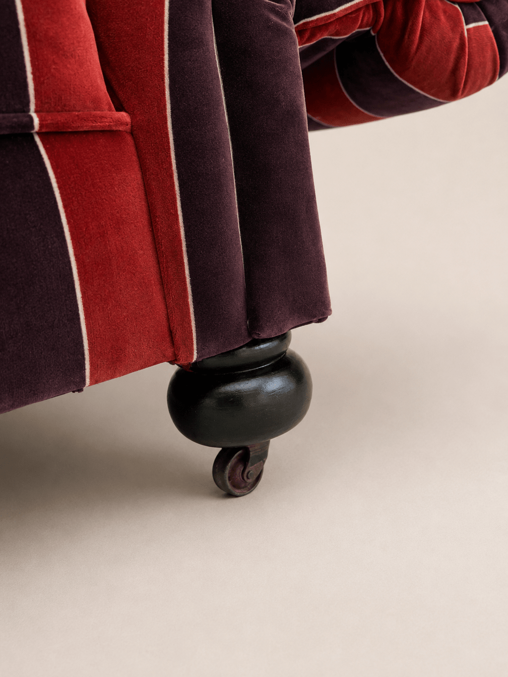 striped velvet curved-back two-seater sofa - turned bun foot and brass castor, close-up