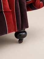 striped velvet curved-back two-seater sofa - turned bun foot and brass castor, close-up